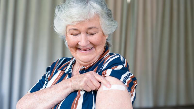 Äldre kvinna som vaccinerat sig och har ett plåster på överarmen