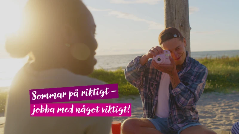 En man som fotograferar på stranden.