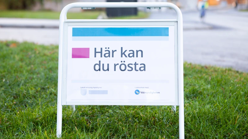 En skylt på en gräsmatta med texten Här kan du rösta