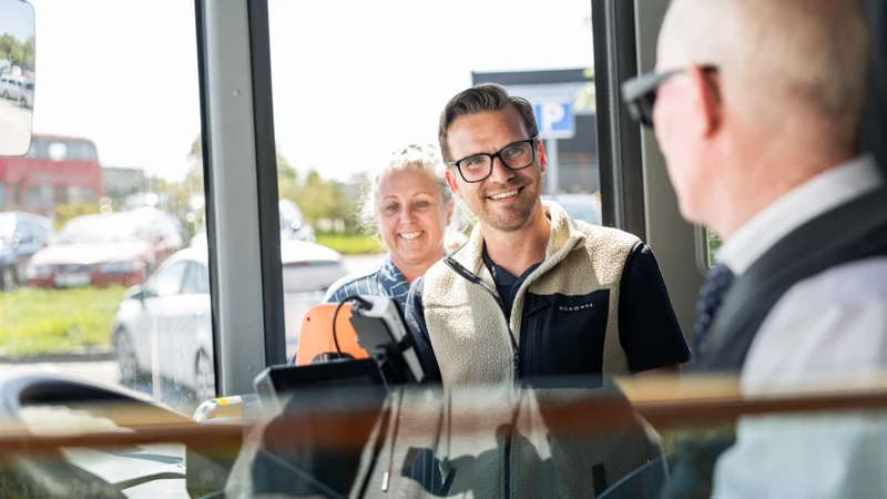 Glada resenärer väntar på att kliva in bussen, chaufför