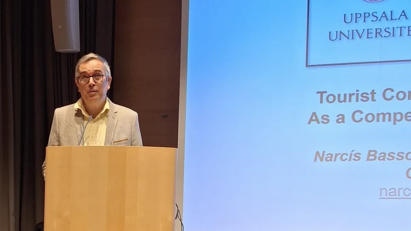 En man som står vid ett talarstativ framför en projektionsduk.