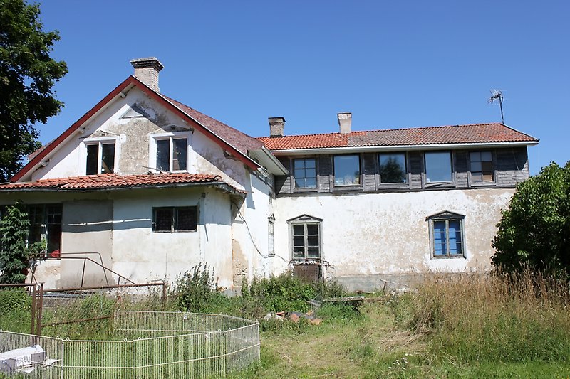 Ett vitt hus på landsbygden som är under renovering.