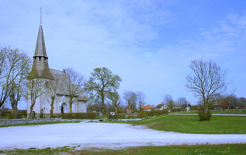 En kyrka och en kyrkogård ligger längs vägen.