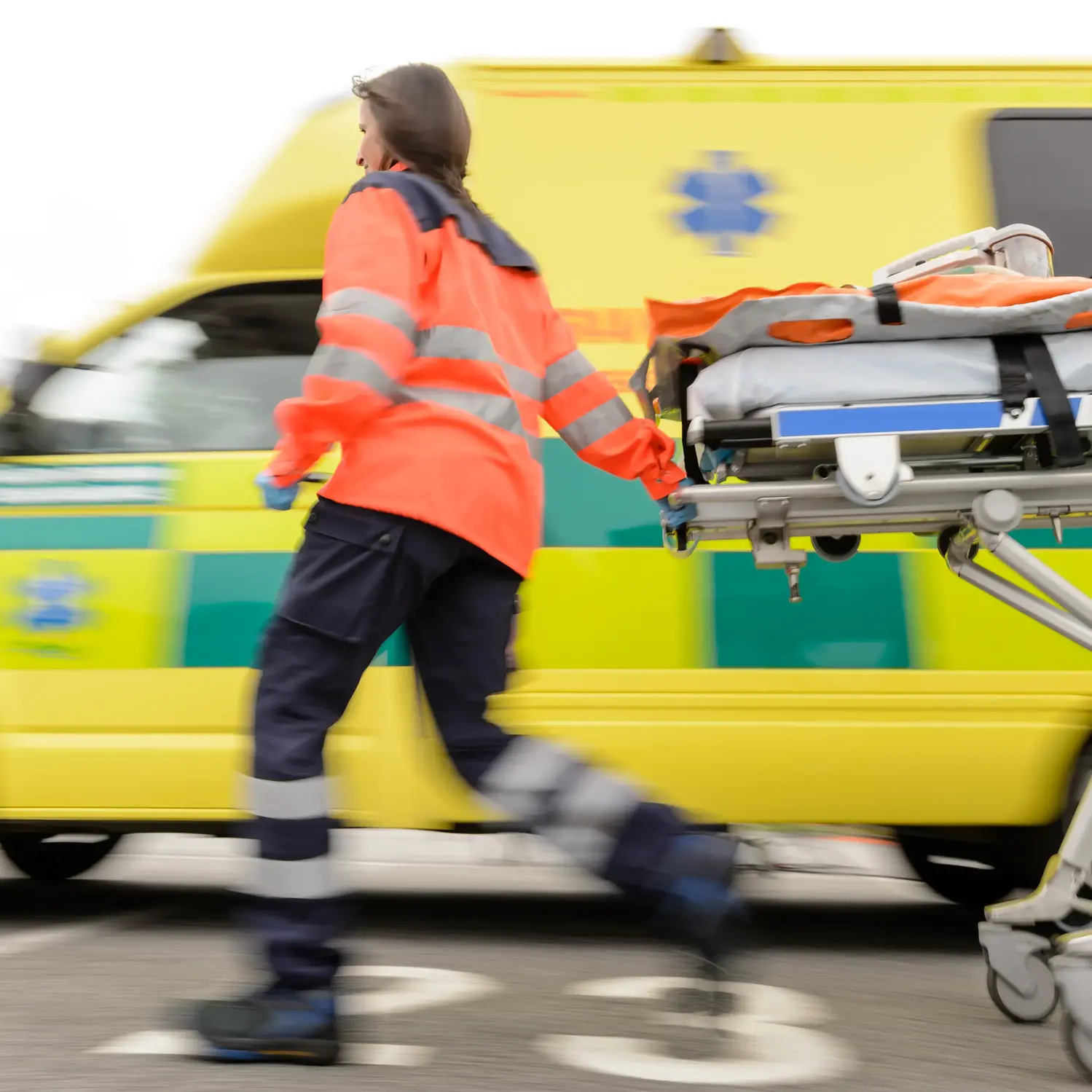 Ambulans och personal med bår, under utryckning
