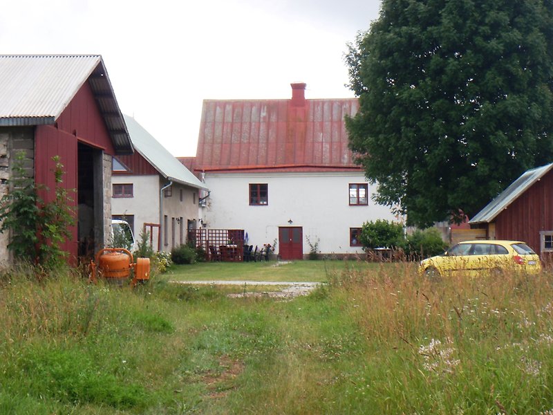 Flera vita hus med röda fönster, röda dörrar och ett plåttak.