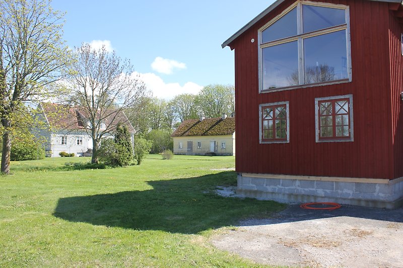 Ett rött hus med två små och ett stort fönster.