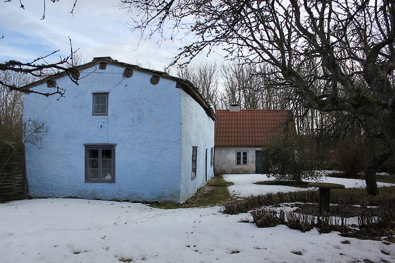 Två vita byggnader med blåvita fönster och blåa dörrar.