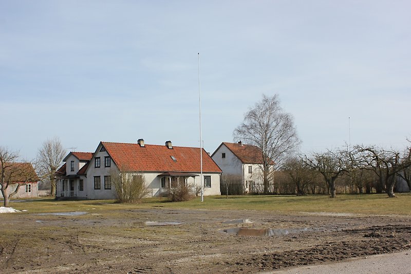 två vita hus syns på baksidan av åkern