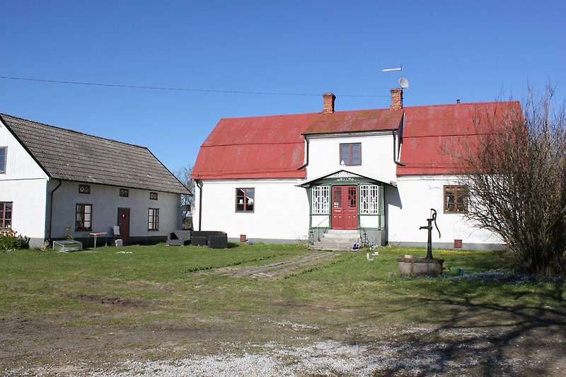 Två vita hus med bruna fönster och röda dörrar.