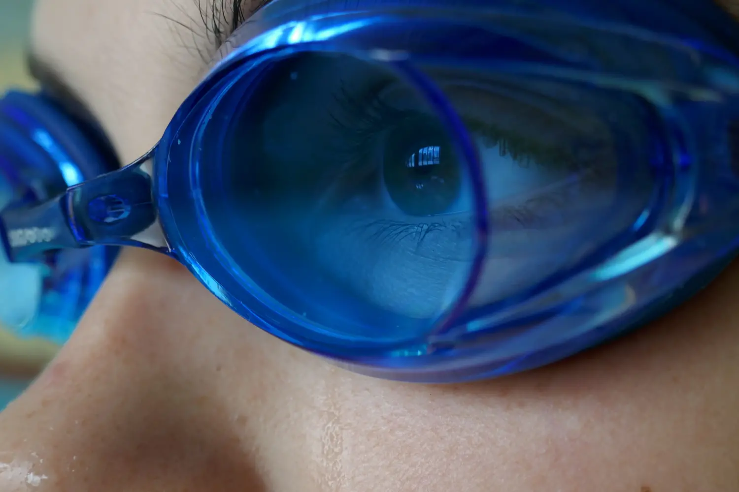 Närbild på ett barn med blå simglasögon.