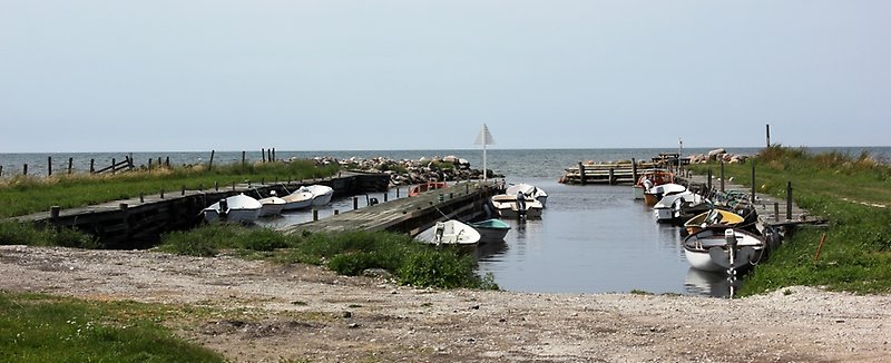 Tiotals båtar är parkerade i närheten av fiskebodar.
